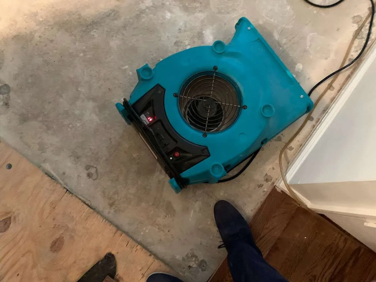 Air mover drying subfloor during Commercial Water Damage Restoration in Town and Country